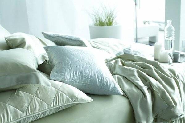 Cama con sábanas claras y luz suave de noche